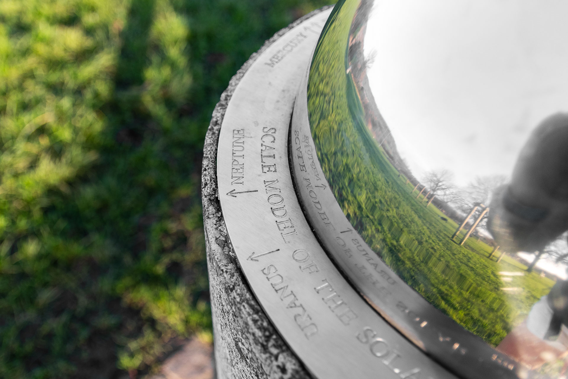 A reflective dome on a grey pillar, with the names of planets around the bottom of the dome, marking the  start of the Otford Solar System walk.