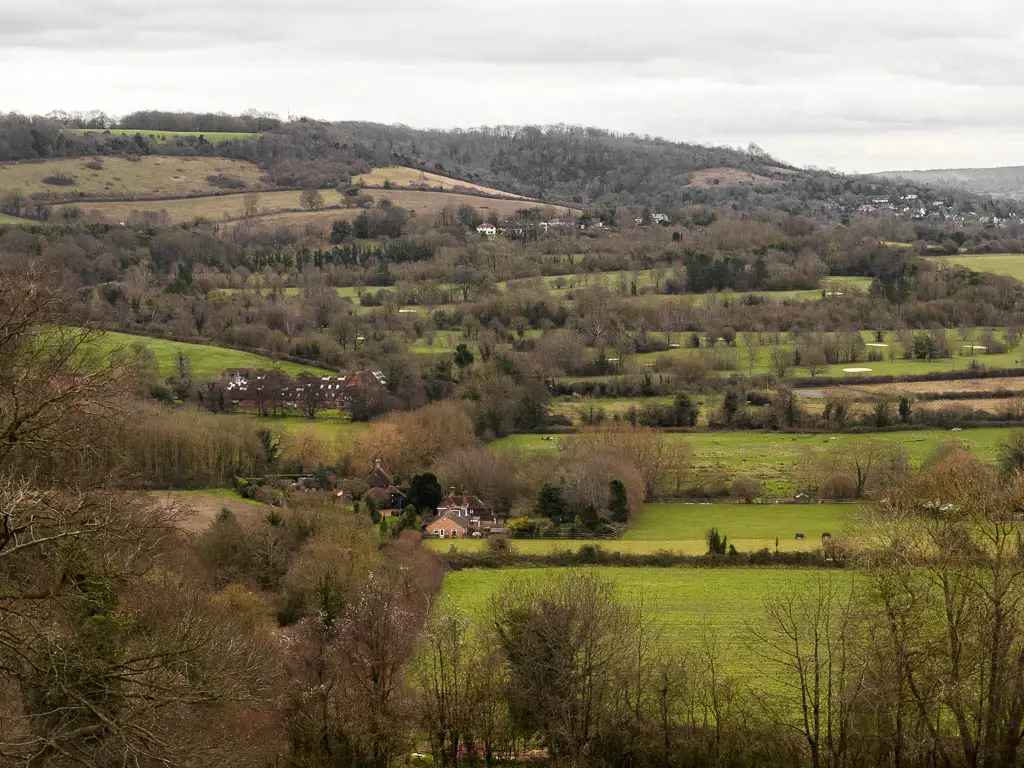 Looking down the valley filled with a mix of fields, trees, and cottages dotted about, when walking from Otford to Shoreham.