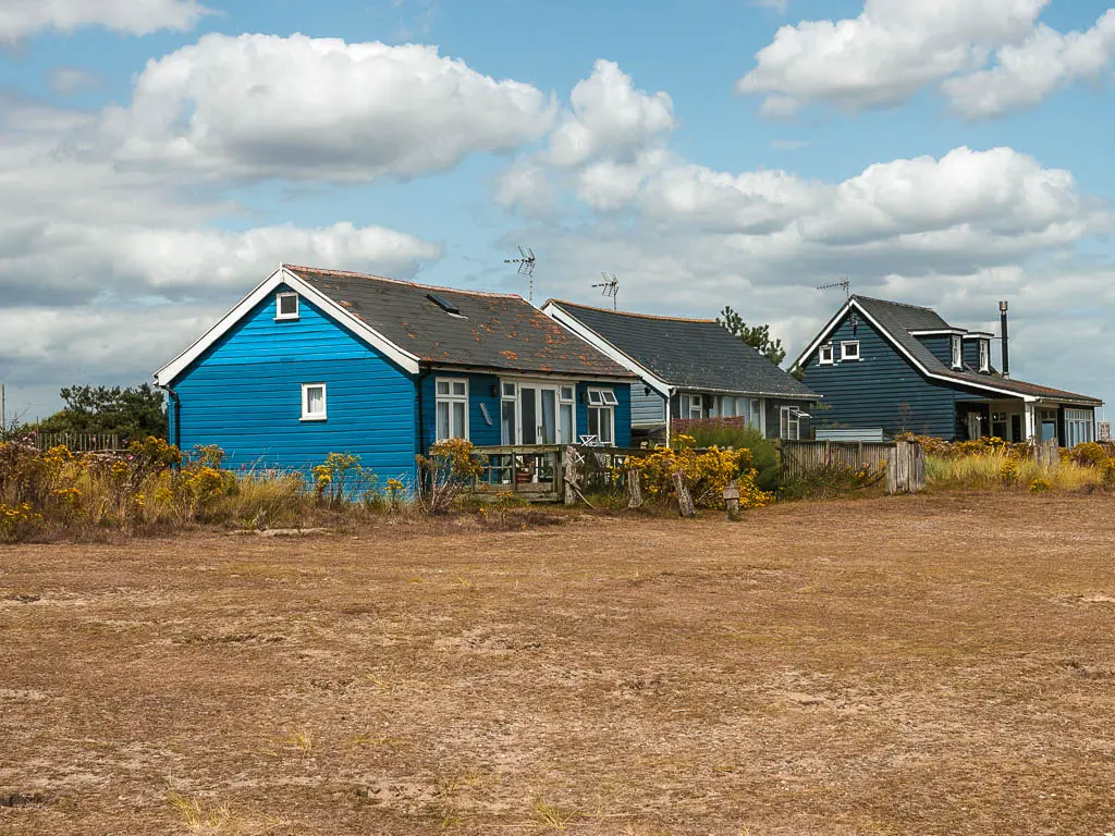 blue timber framed cottages across the barren field. 