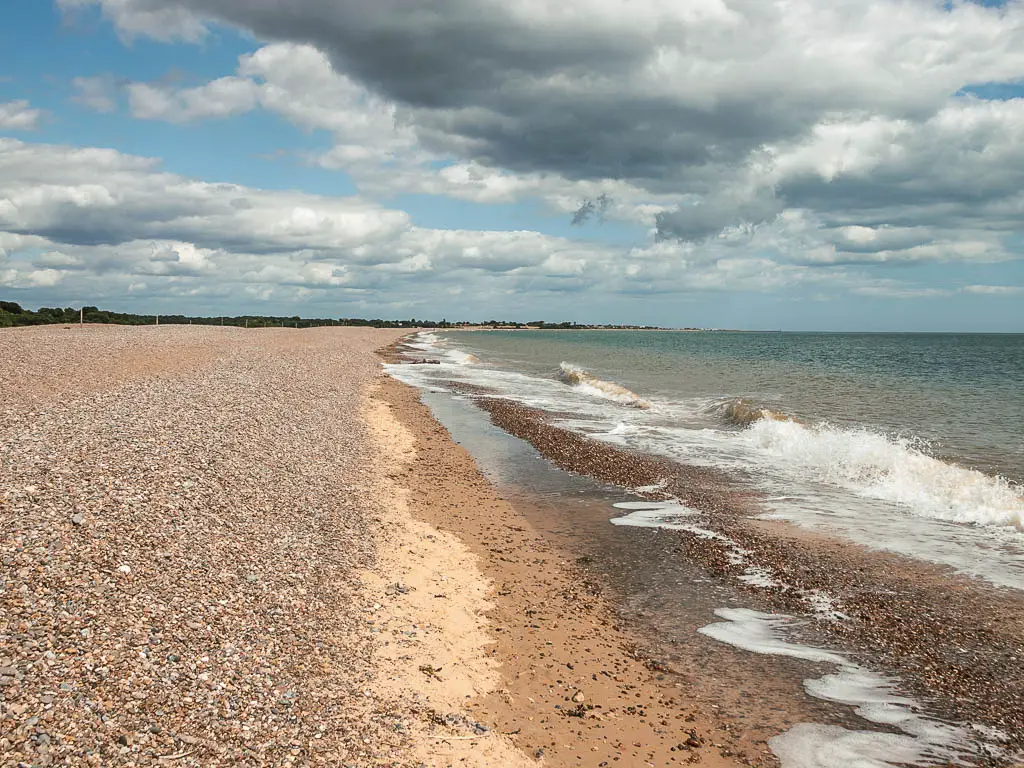 A shingle beach leading straight ahead, with the sea to the right, on the walk from Dunwich to Kessingland.