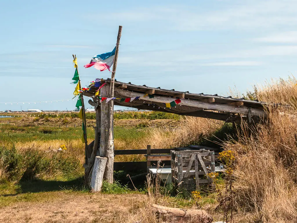 A wooden shelter shack, with bunting and a flag flying.