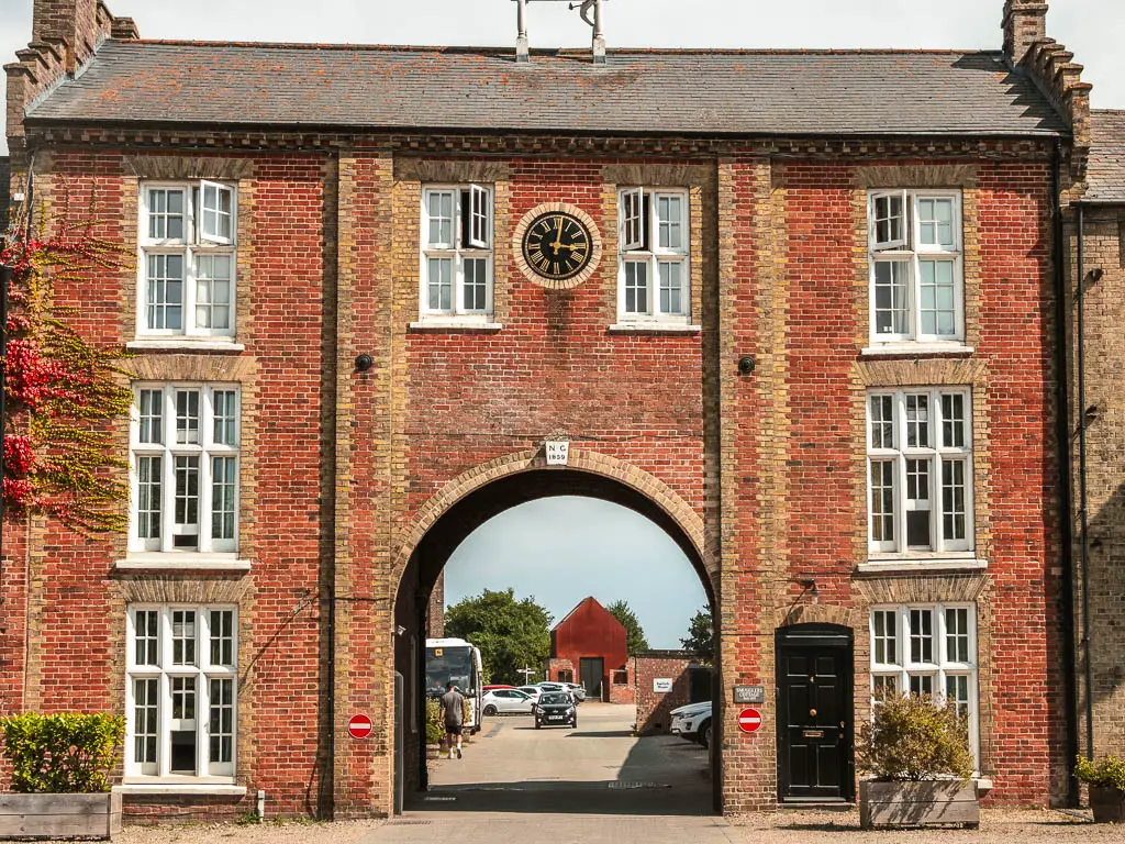 Looking through the arch in the middle of a large brick house. 